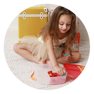 young girl sitting and eating from lunchbox